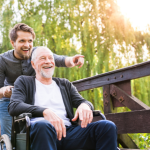 How to Choose the Best Wheelchair for Elderly Seniors - Adult son pushing dad in wheelchair